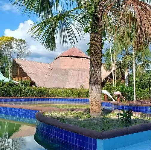Pool and thatched buildings of BioHotel Arará on the Amazon River