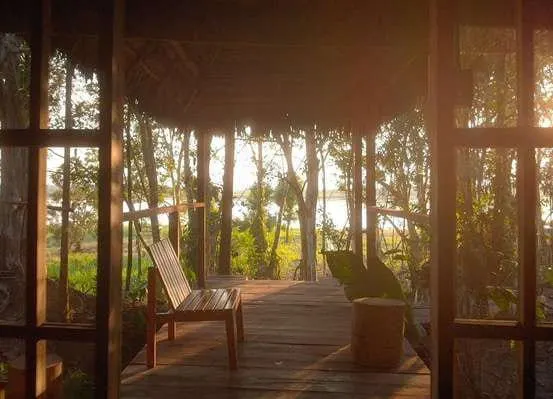 Terraza de madera de Chunaki Ecolodge rodeada de selva