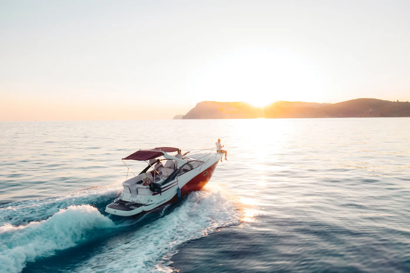 Sport boat speeding across the sea at sunset