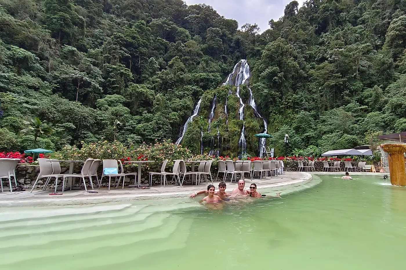 Thermal pool and wooden cabins in a green mountain valley