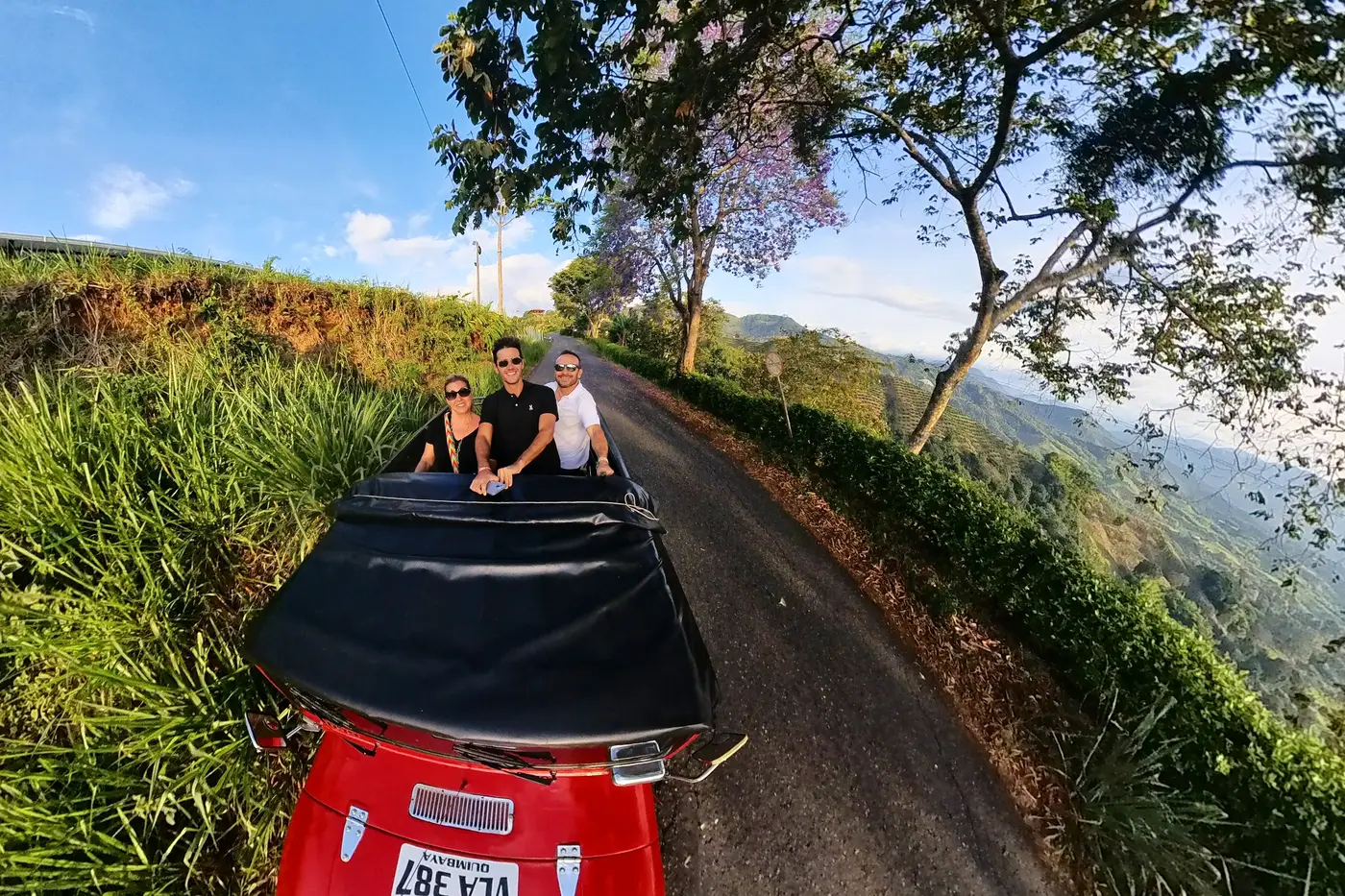 Red Willys jeep driving along a mountain road in the Cordillera