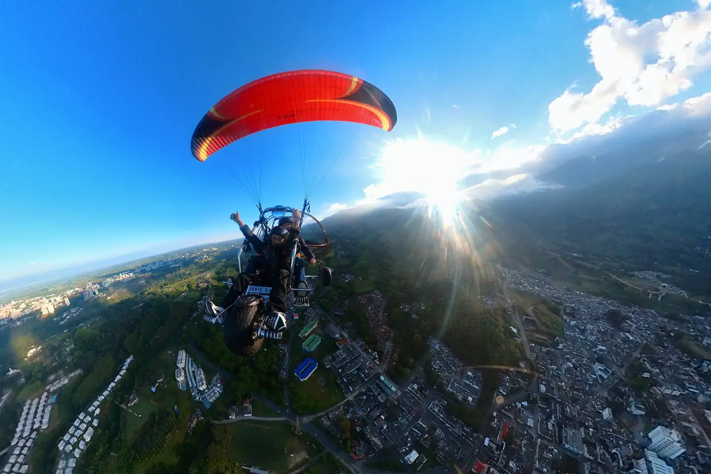 Paratrike with a red wing flying above the clouds in Quindío