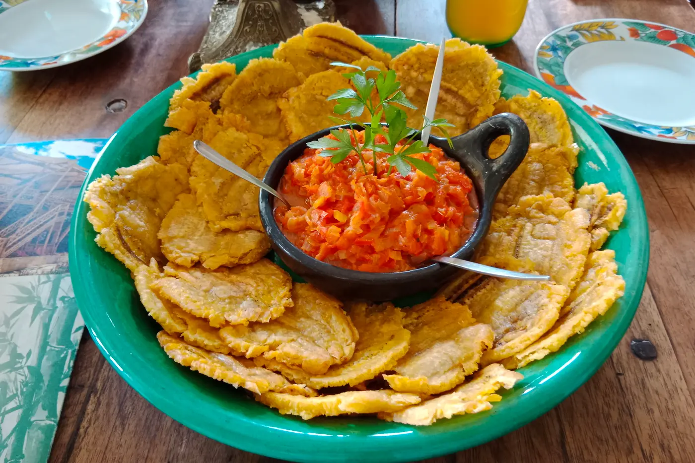 Fried green plantain tostones served with hogao sauce