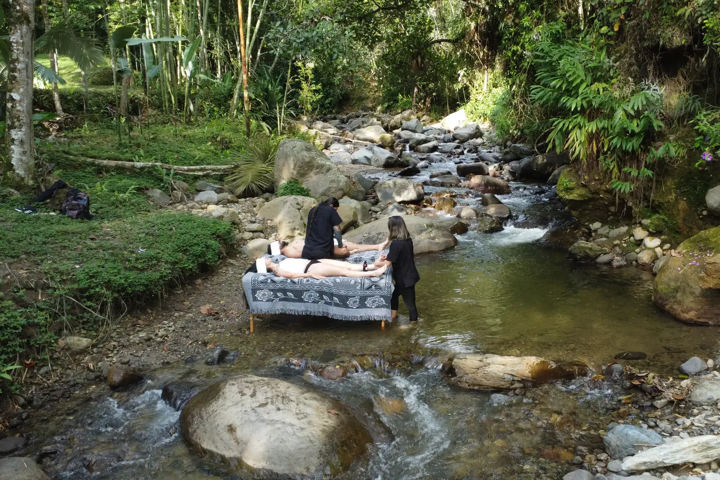 Massage tables set in a mountain stream at a wellness retreat