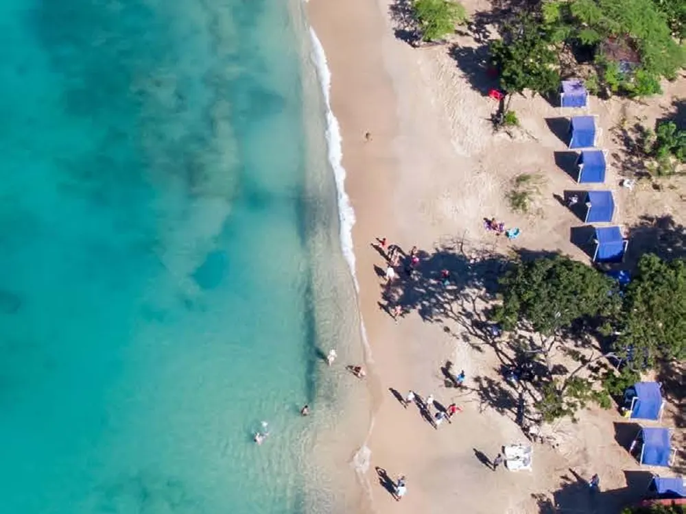 Pale-sand beach and turquoise water seen from above