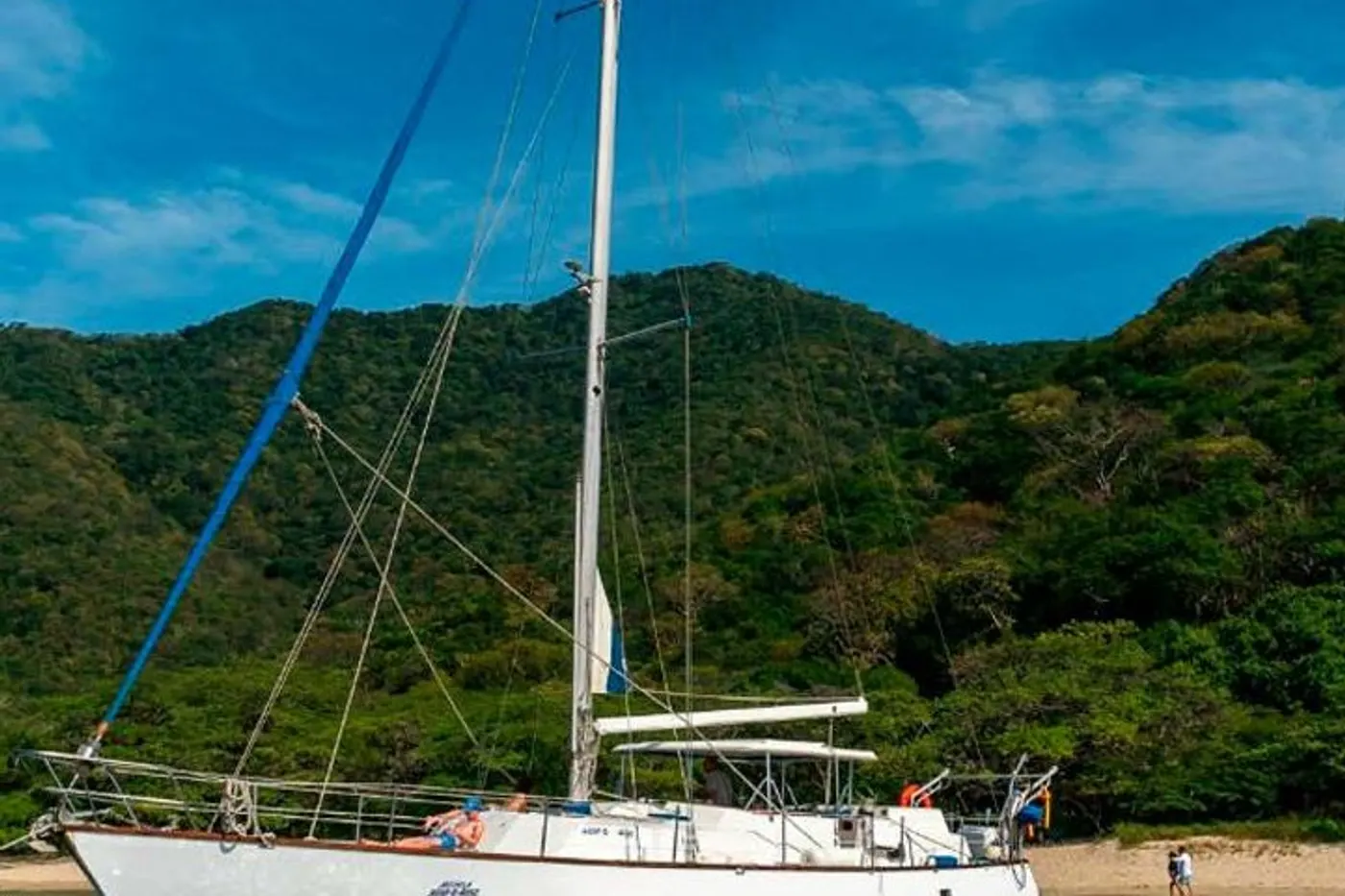 Sailboat anchored off the green coast of Tayrona Park