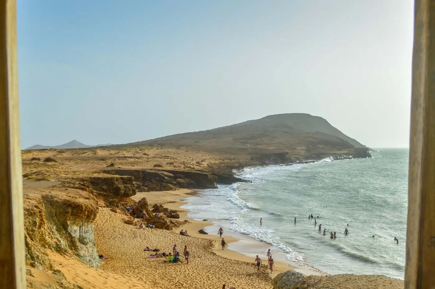 Golden-sand beach and sea in front of a hill in La Guajira