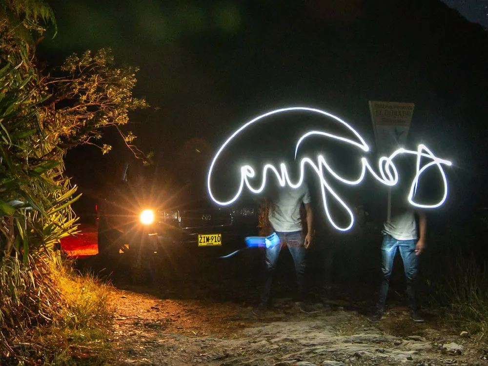 Travelers with a light on a starry night in the Sierra Nevada
