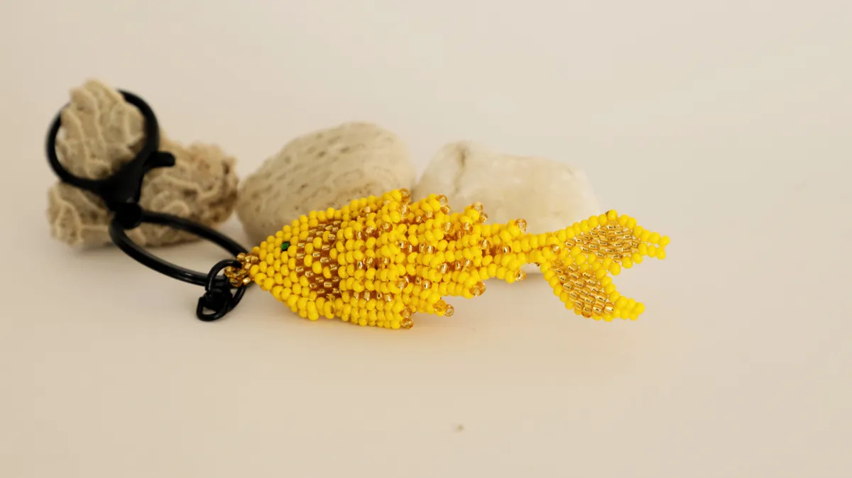 Beaded fish keychain resting on a stone