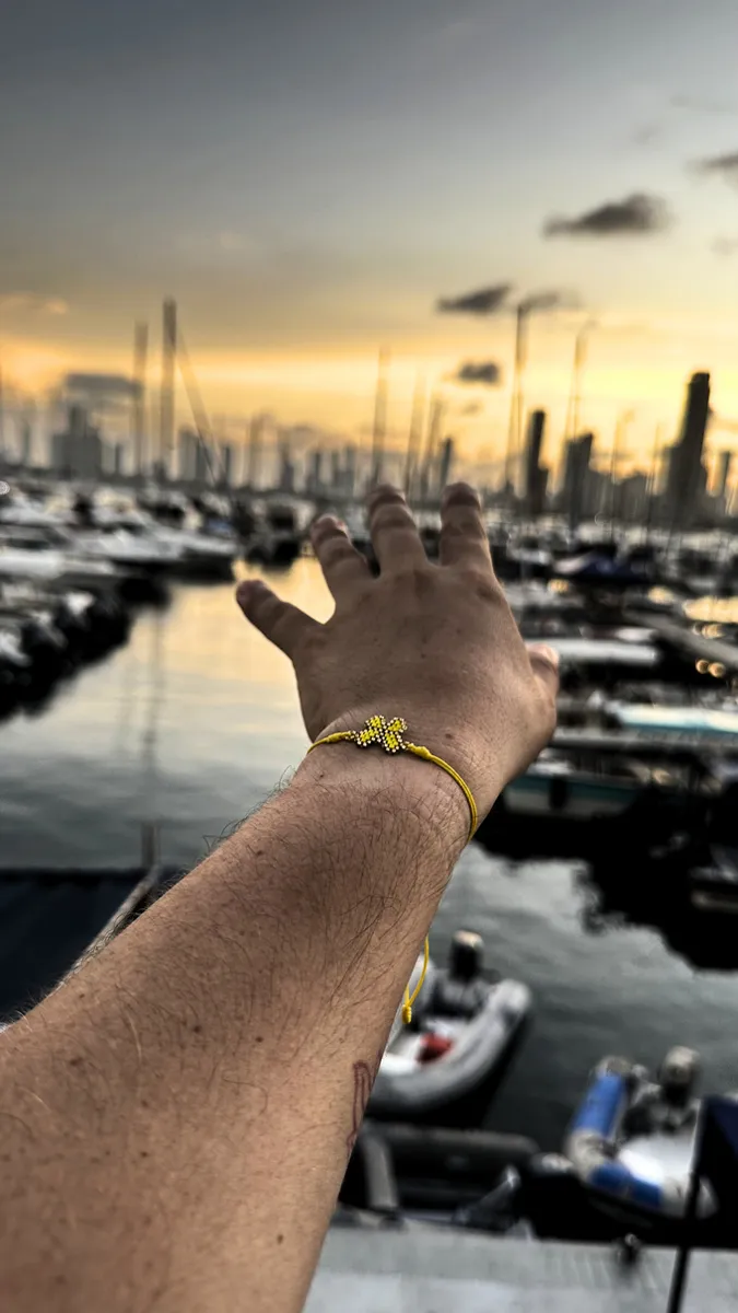 Butterfly bracelet worn on a wrist by the marina at sunset