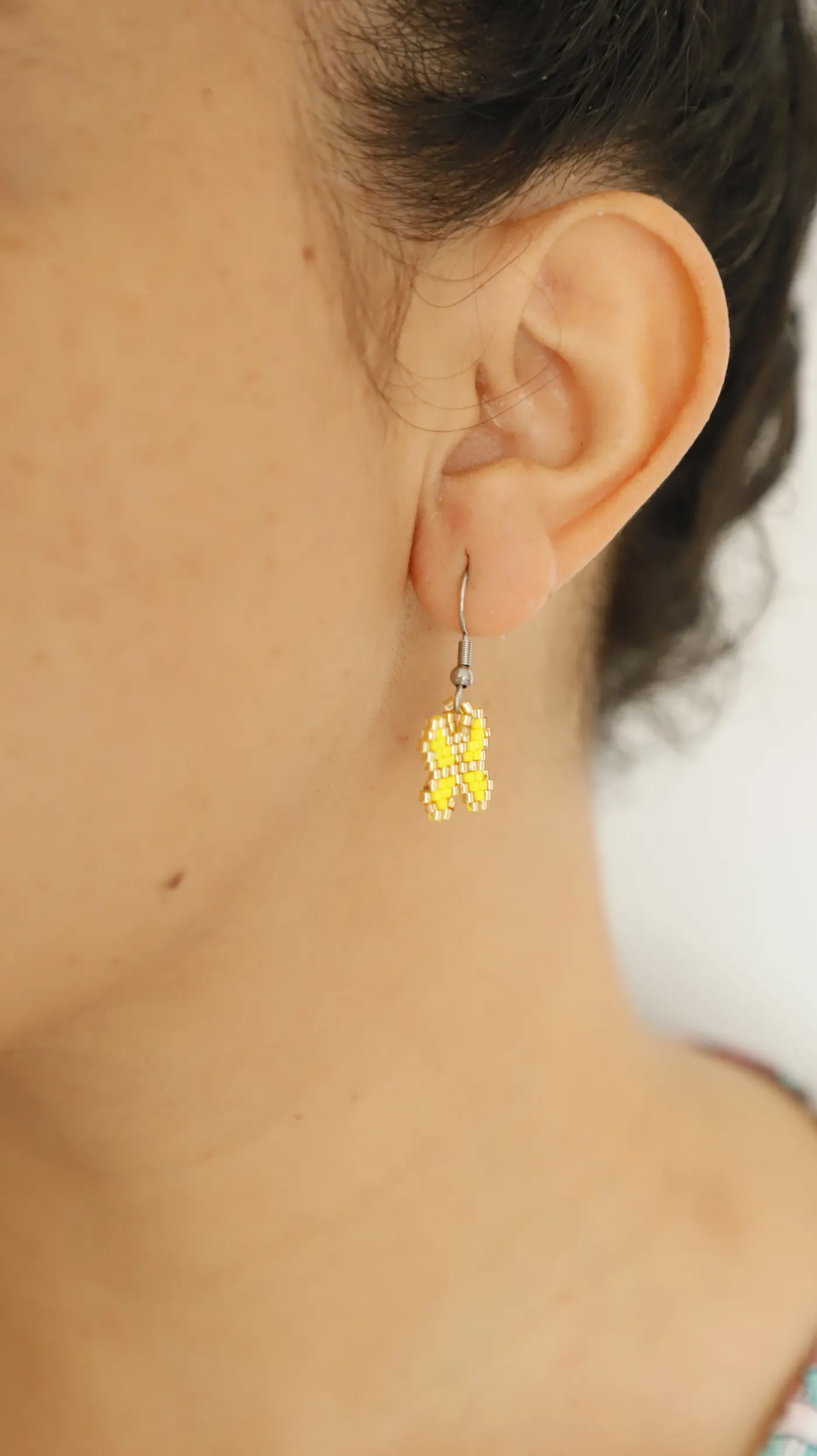 A butterfly earring worn on an ear