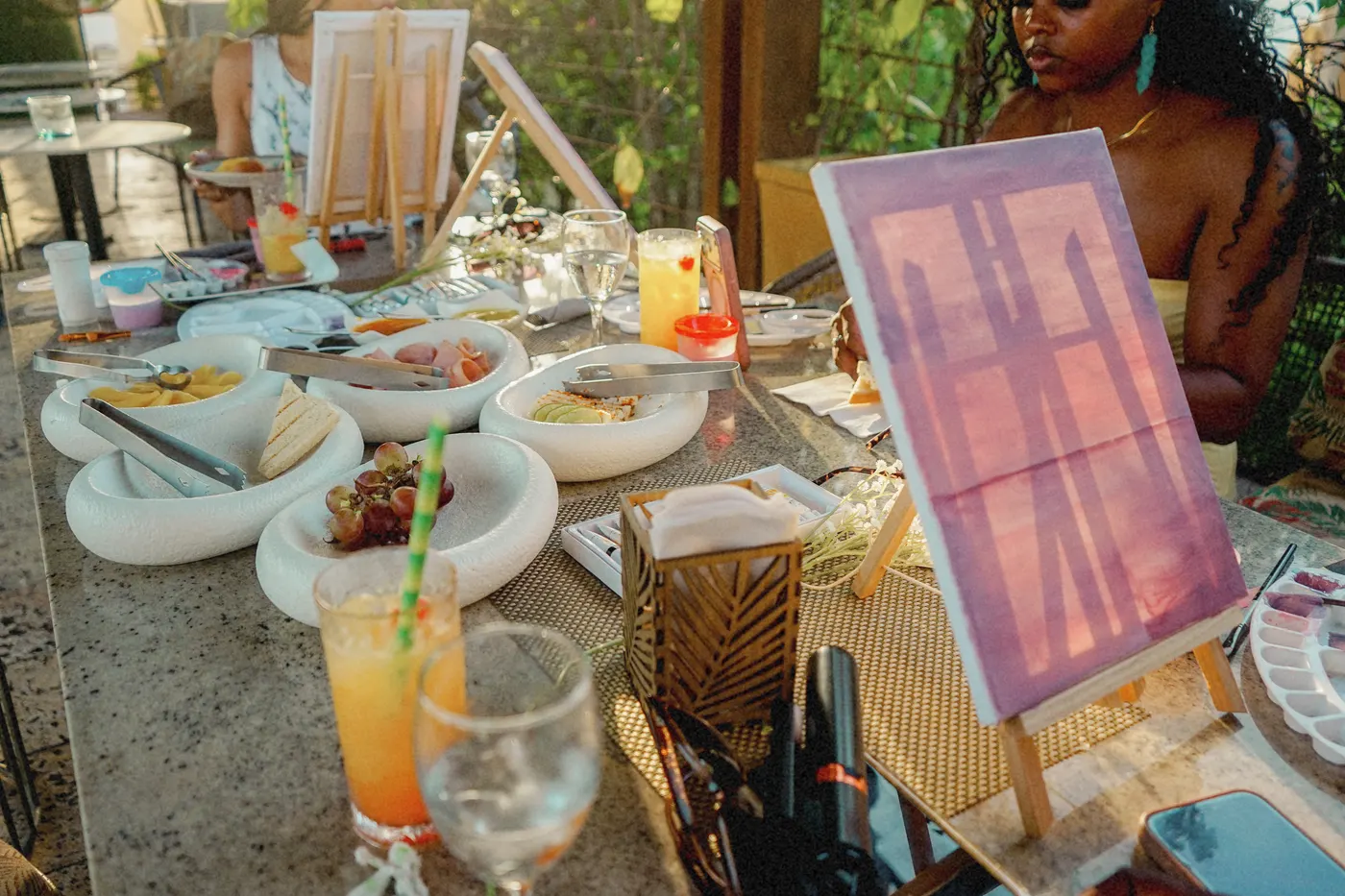 Table with brunch dishes, fresh juice and a painted canvas