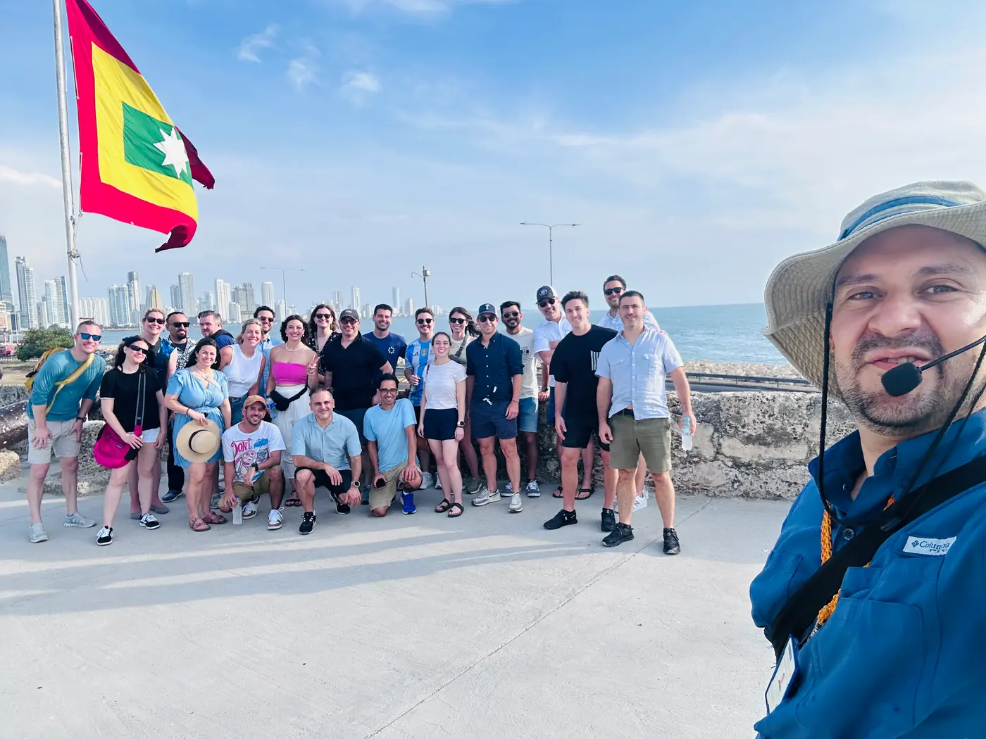 Group of visitors on the walls of Cartagena with a Colombian flag
