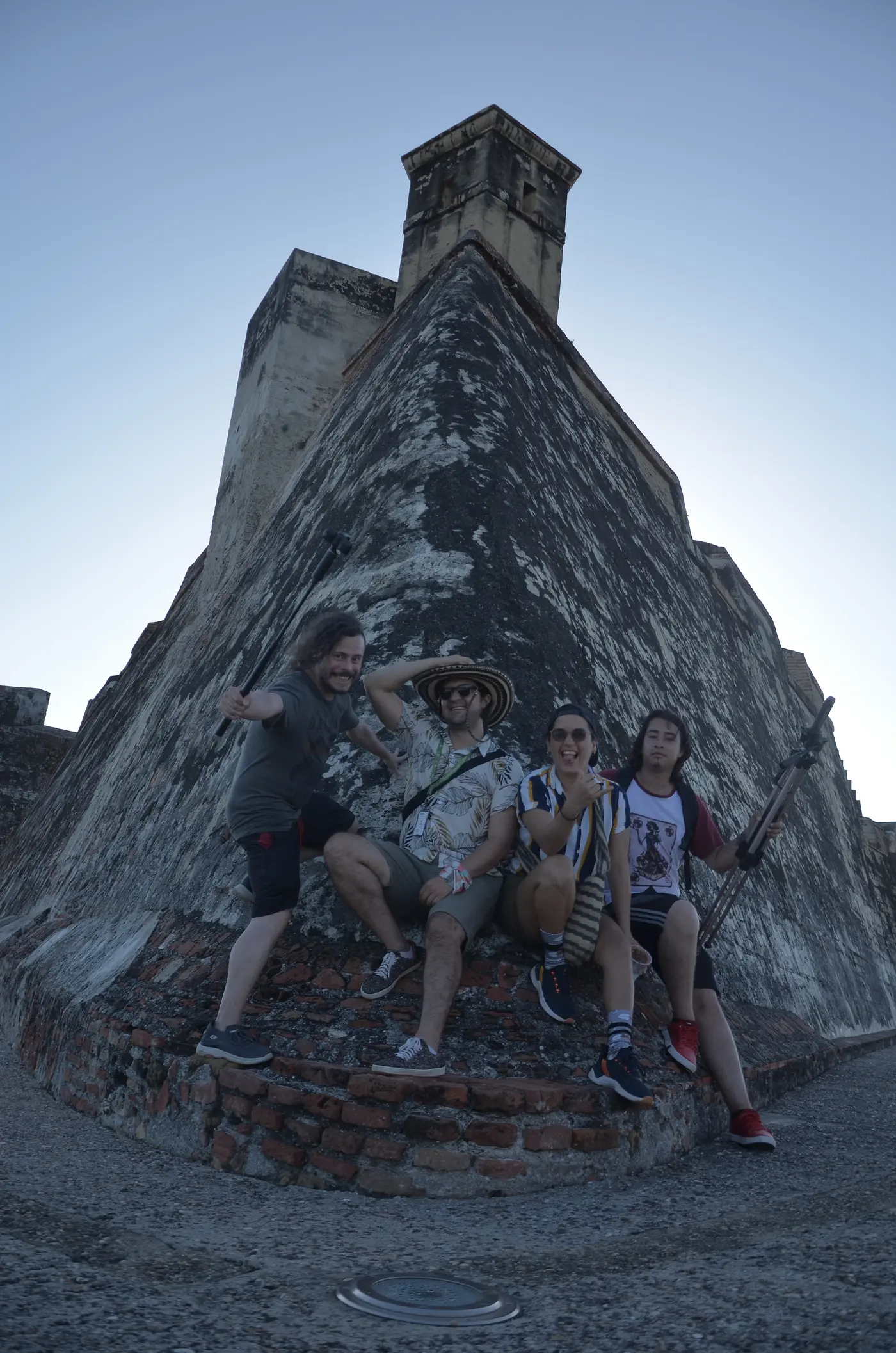 Visitantes posando junto a un muro de piedra de la fortaleza