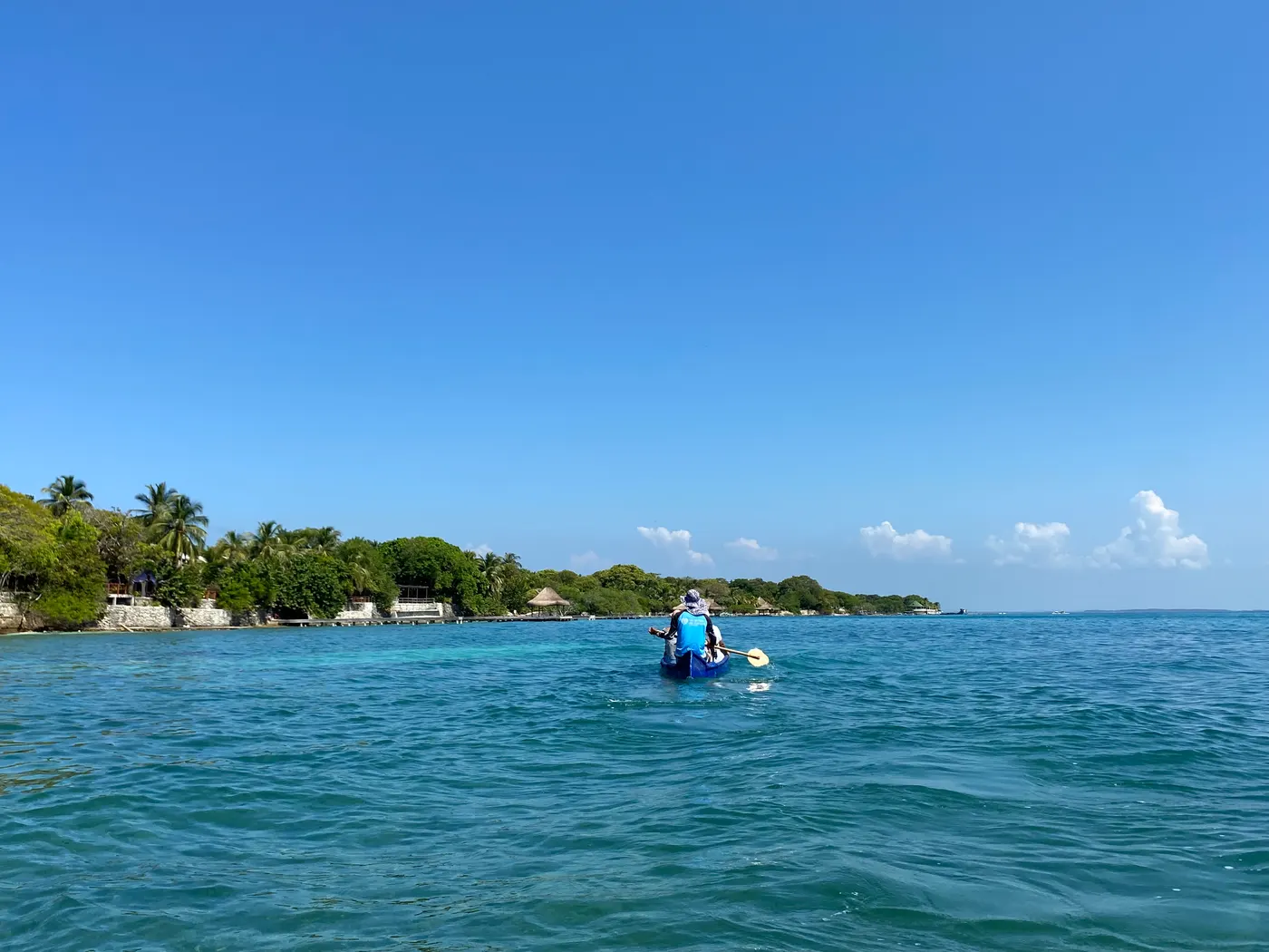 A kayaker paddling in turquoise water off the Rosario Islands coast