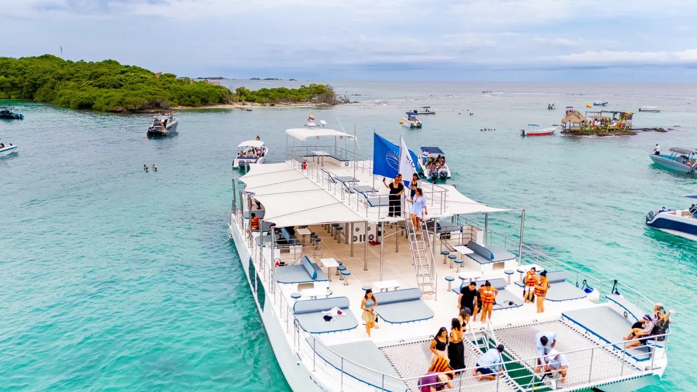 Aerial view of the catamaran with guests on deck in turquoise water