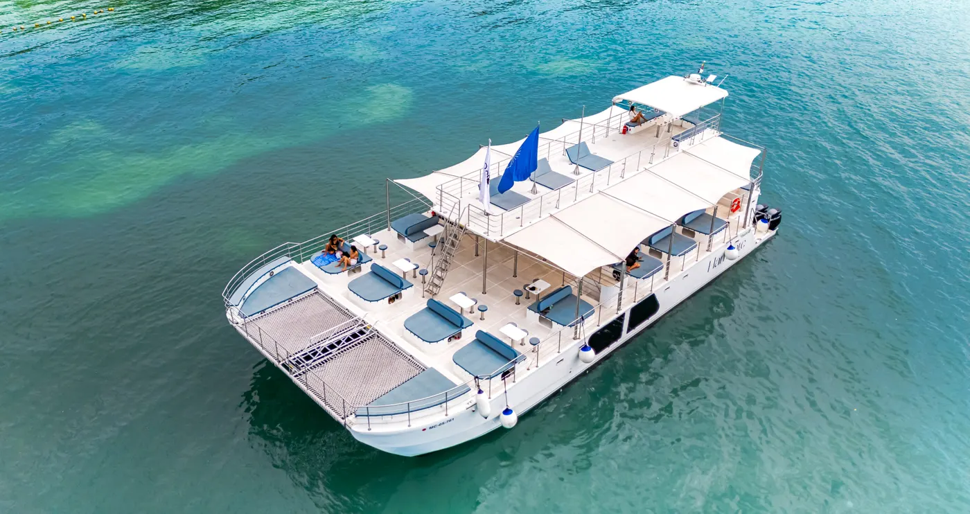 Aerial view of the catamaran with its shaded deck in clear water