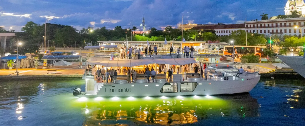 Guests on the deck of the catamaran at the pier at dusk