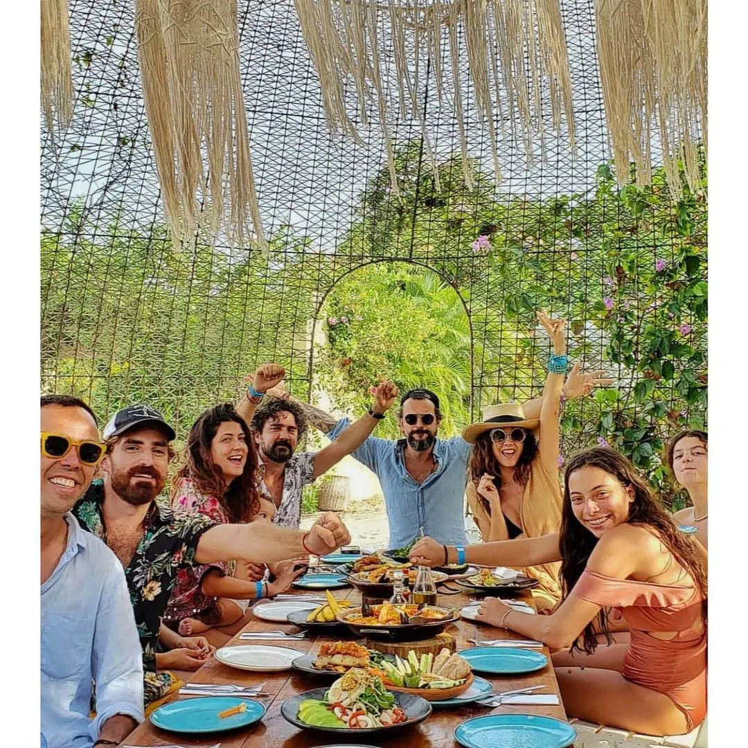 Amigos compartiendo una comida en una mesa de un restaurante con jardín