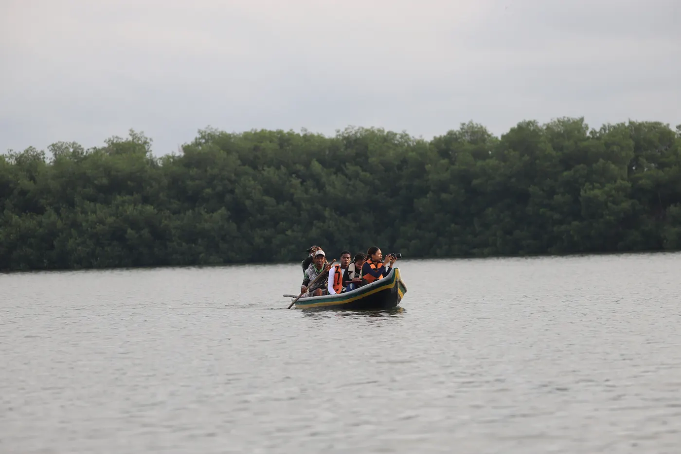 A canoe with birdwatchers crossing a lagoon