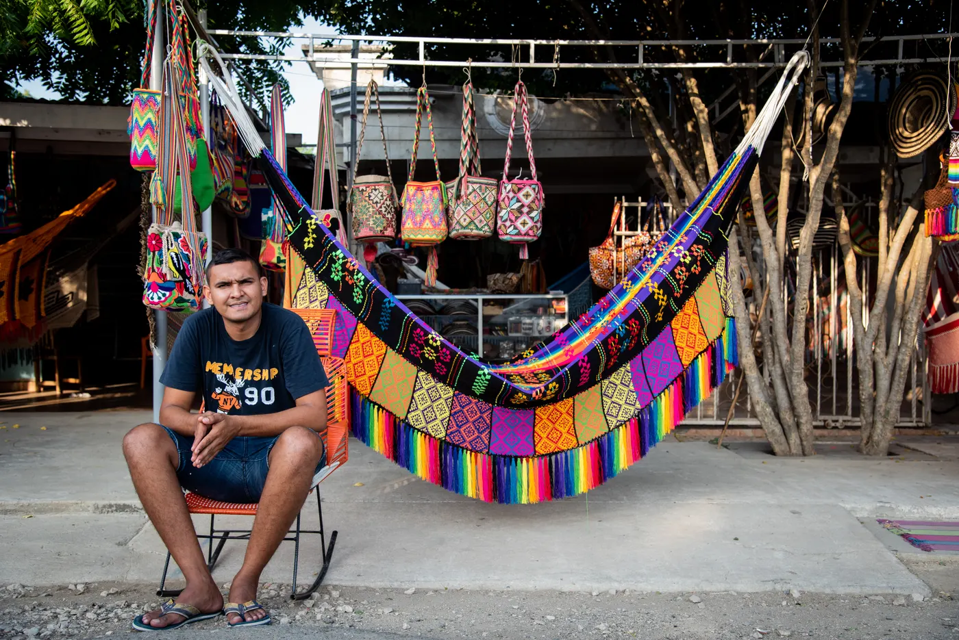 Artisan sitting in front of colorful hammocks and bags in San Jacinto