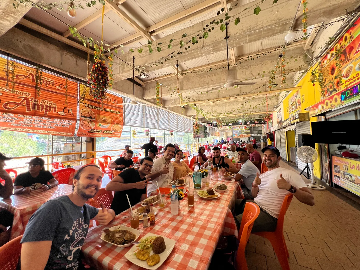 Long table of guests sharing a meal in a market restaurant in Cartagena